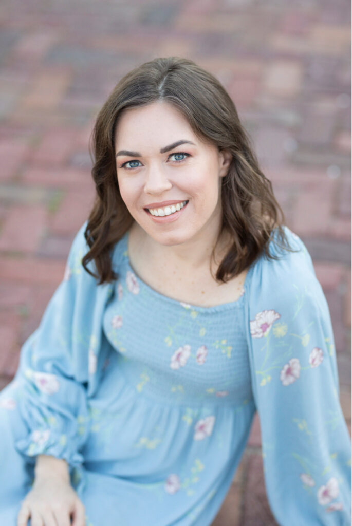 woman in flower dress smiling at the camera